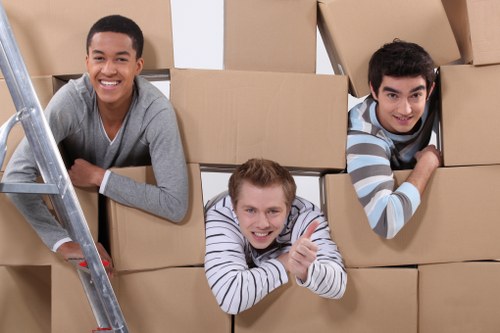 Household boxes and furniture being loaded into a moving truck in South Kensington