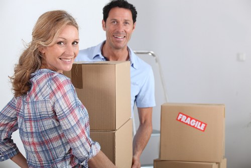 Moving team handling boxes and furniture near Southkensington homes